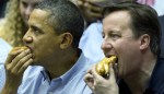 Barack Obama and David Cameron eat hot dogs as they sit in the stands at University of Dayton&nbsp;Arena